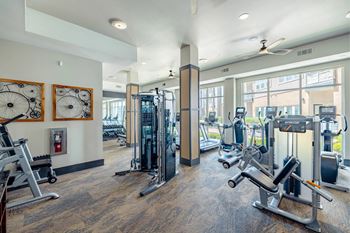 A gym with a variety of equipment including treadmills, weights, and exercise machines. at Bridge at Henley, Austin, TX, 78741